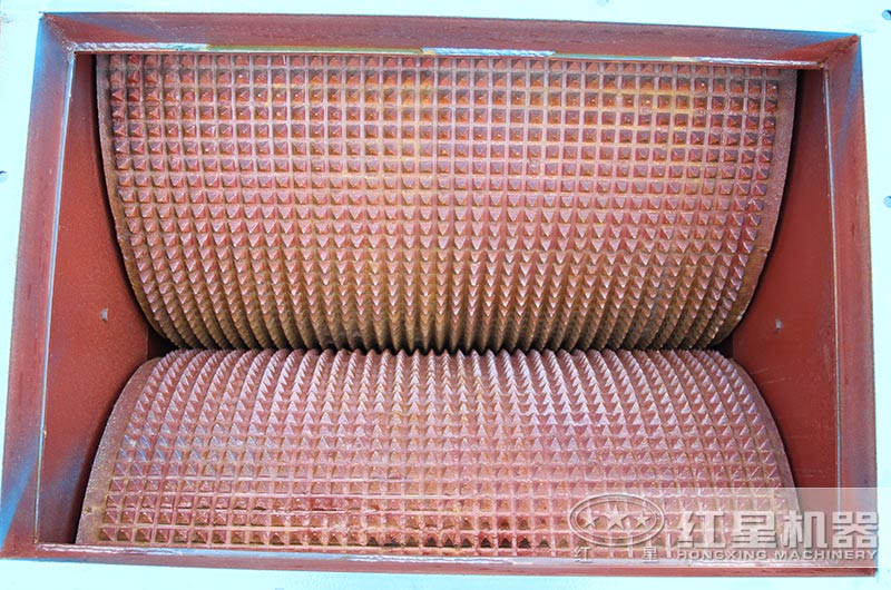 相向轉(zhuǎn)動的兩輥子，調(diào)節(jié)其間隙可改變出料